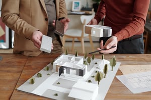 Architekten schauen sich Hausmodell an